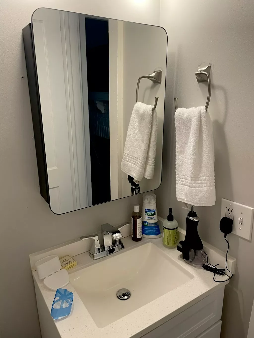 Bathroom vanity, faucet and wall-mounted mirror installed.
