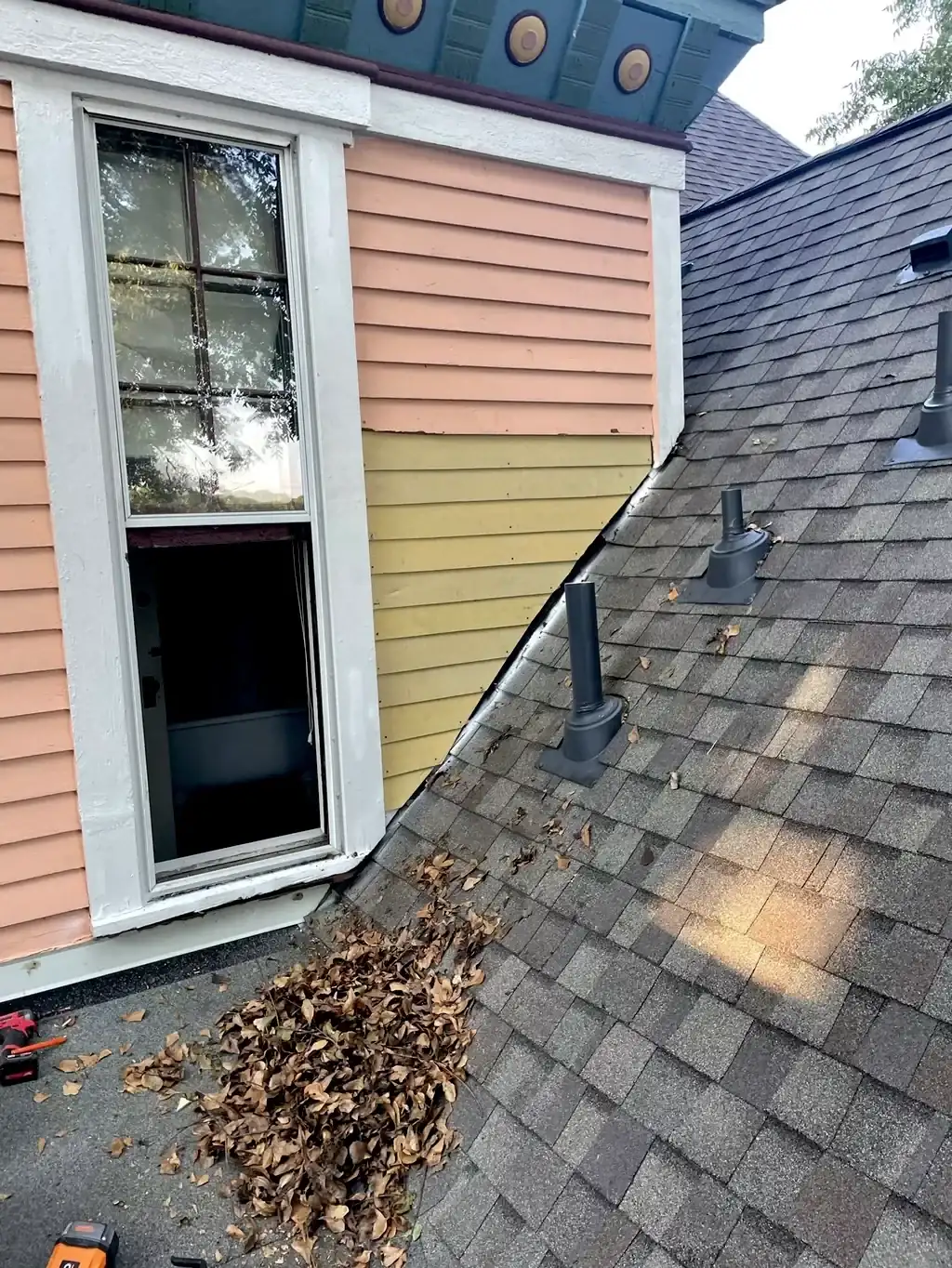 Roof valley and window exterior with debris cleared off the shingles.