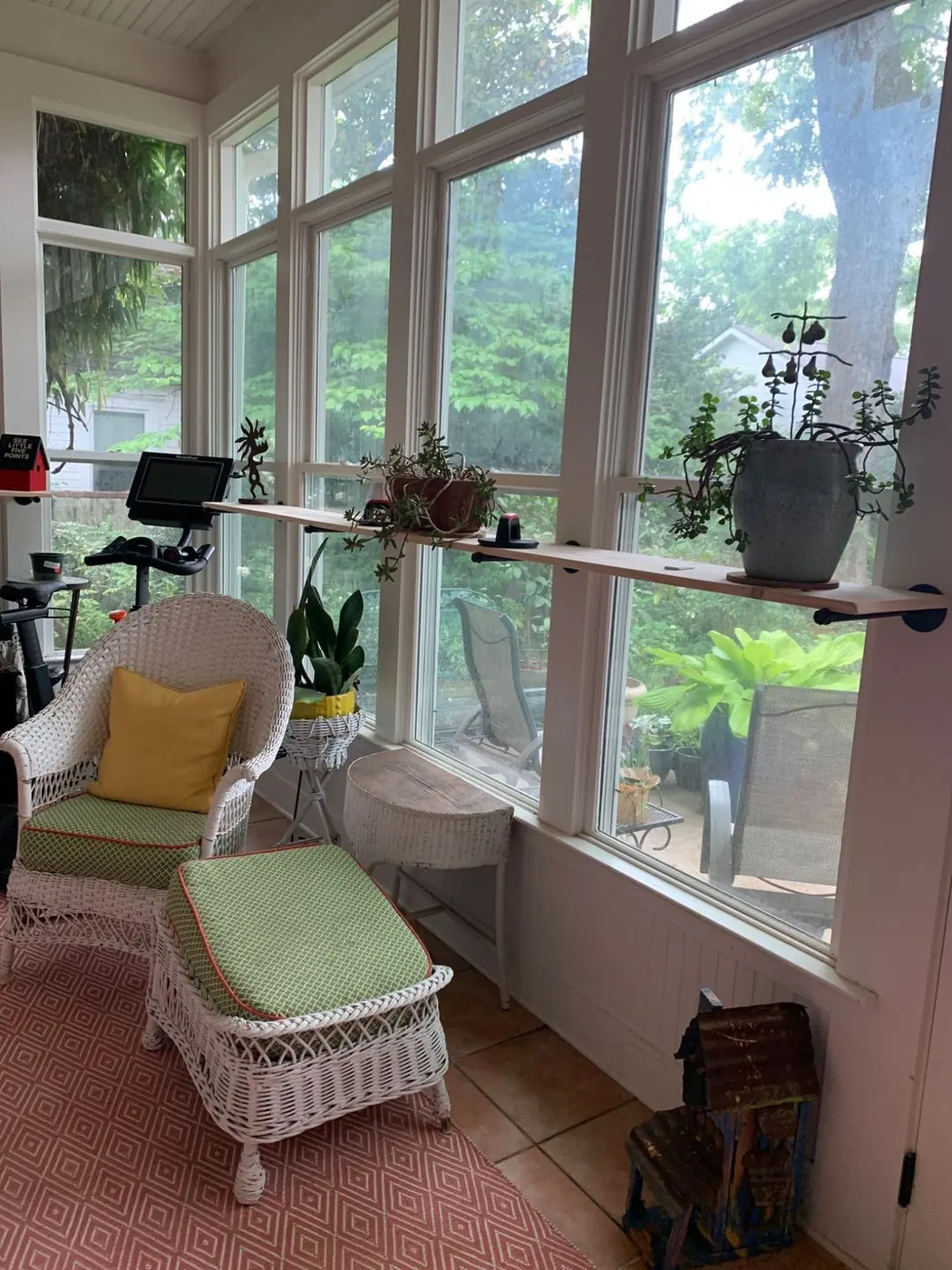 Sunroom with a full wall of divided-light windows and a built-in plant shelf.
